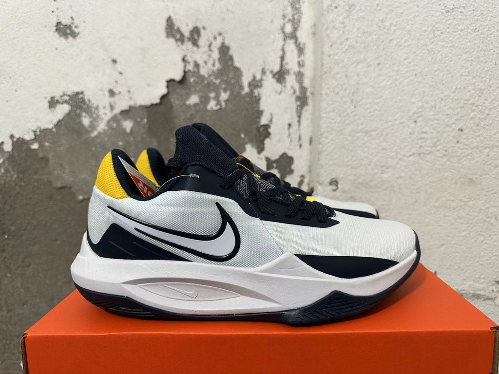 Side view showing the Swoosh logo on a white and navy Nike basketball shoe