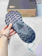 Close view of the dark gray sneaker outsole showing a pronounced lugged tread pattern.