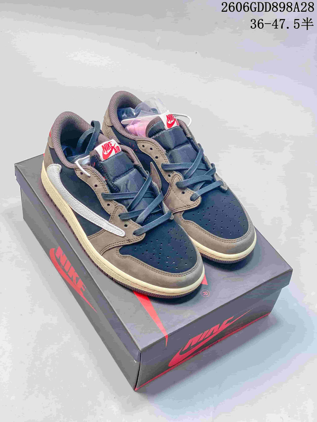 Pair of navy and taupe low-top sneakers on a branded shoebox