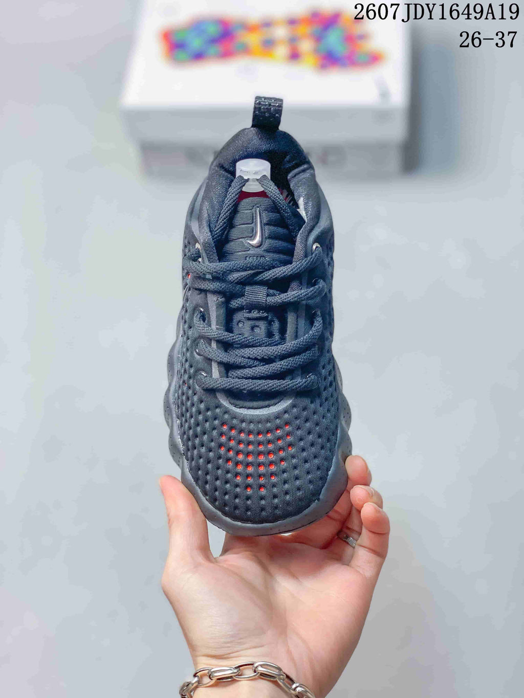 Front view of the black sneaker showing the perforated toe box, laces, tongue, and padded collar.