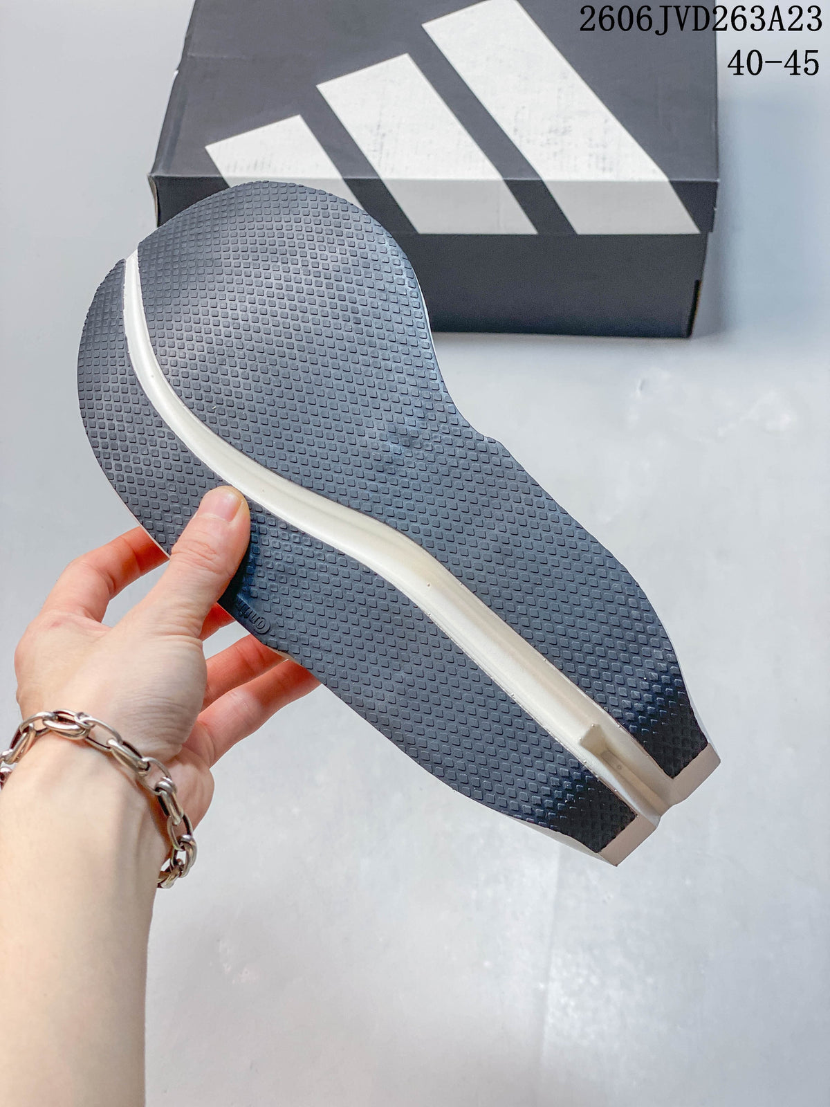 Close-up of the textured dark outsole on a white Adidas Adizero Dropset Elite shoe; image text shows sizes 40–45.