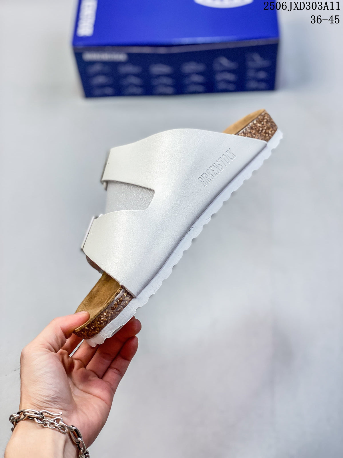 Side view of a white two-strap sandal with a contoured footbed