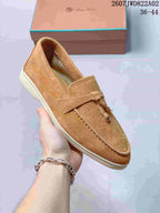 Close view of a tan loafer showing the strap and decorative tassel