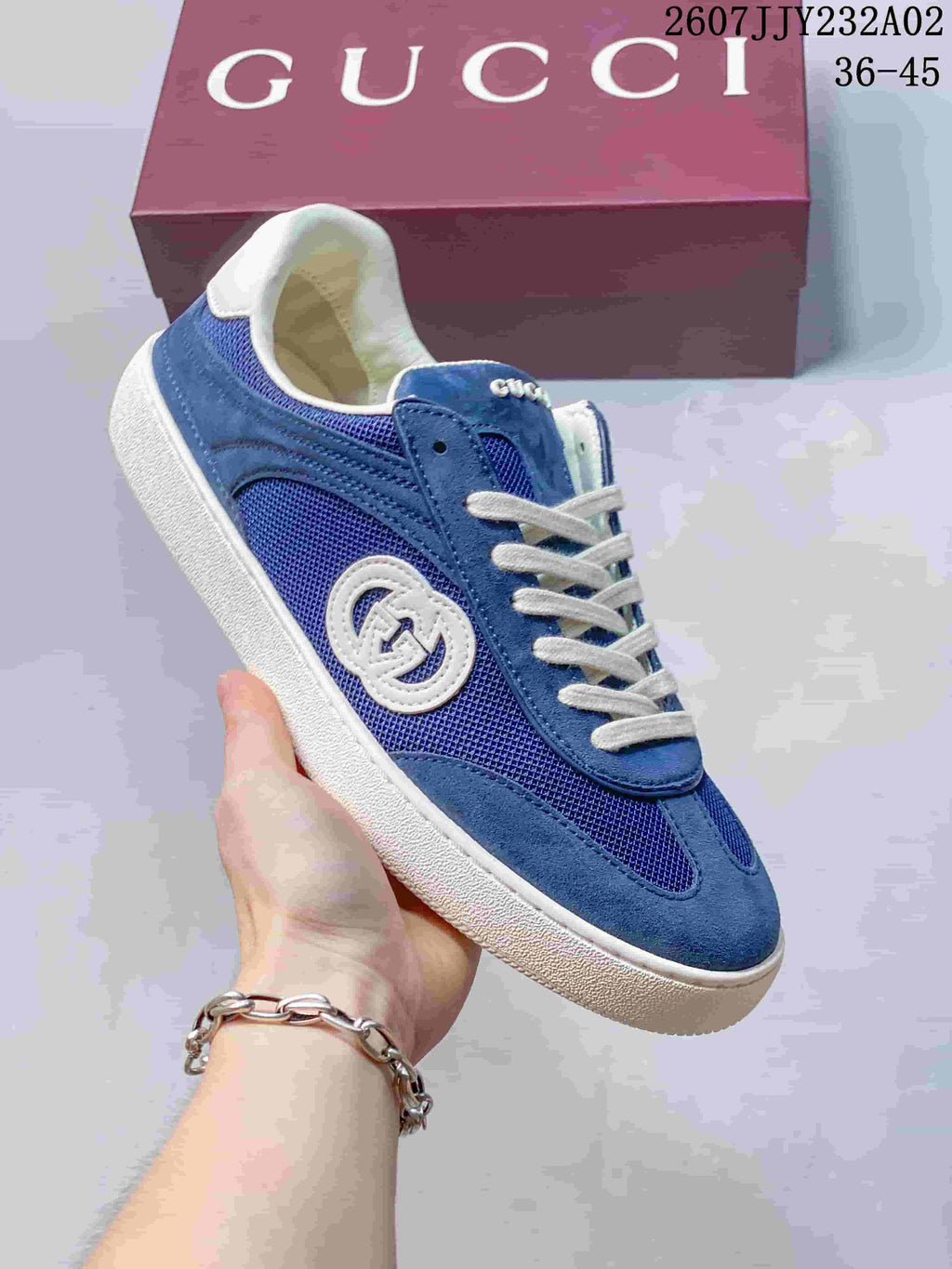 Angled side view of a blue low-top sneaker with white sole and embroidered emblem