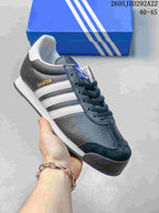 Dark Adidas Samoa sneaker with white side stripes and a white midsole.
