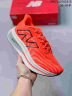 Bright red-orange New Balance running sneaker with a black outlined logo and white midsole.