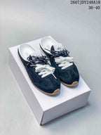 Navy alo Sunset mule sneakers with white and navy laces displayed on a white shoebox.