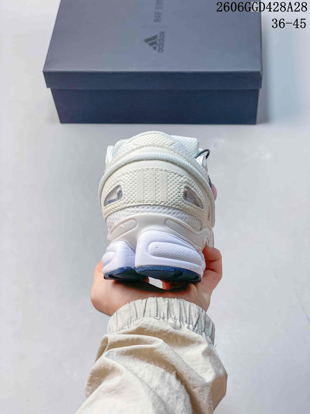 Rear view of a white low-top sneaker with a sculpted heel and navy outsole details