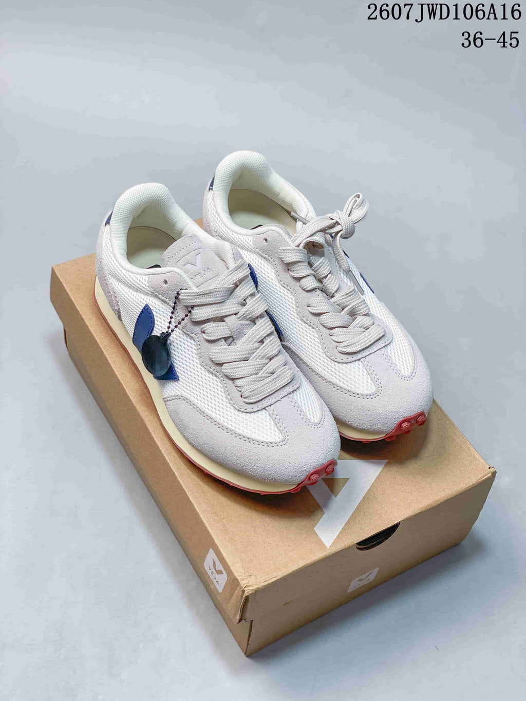 Pair of white and blue VEJA sneakers displayed on a branded box, with the style code and EU size range visible above.