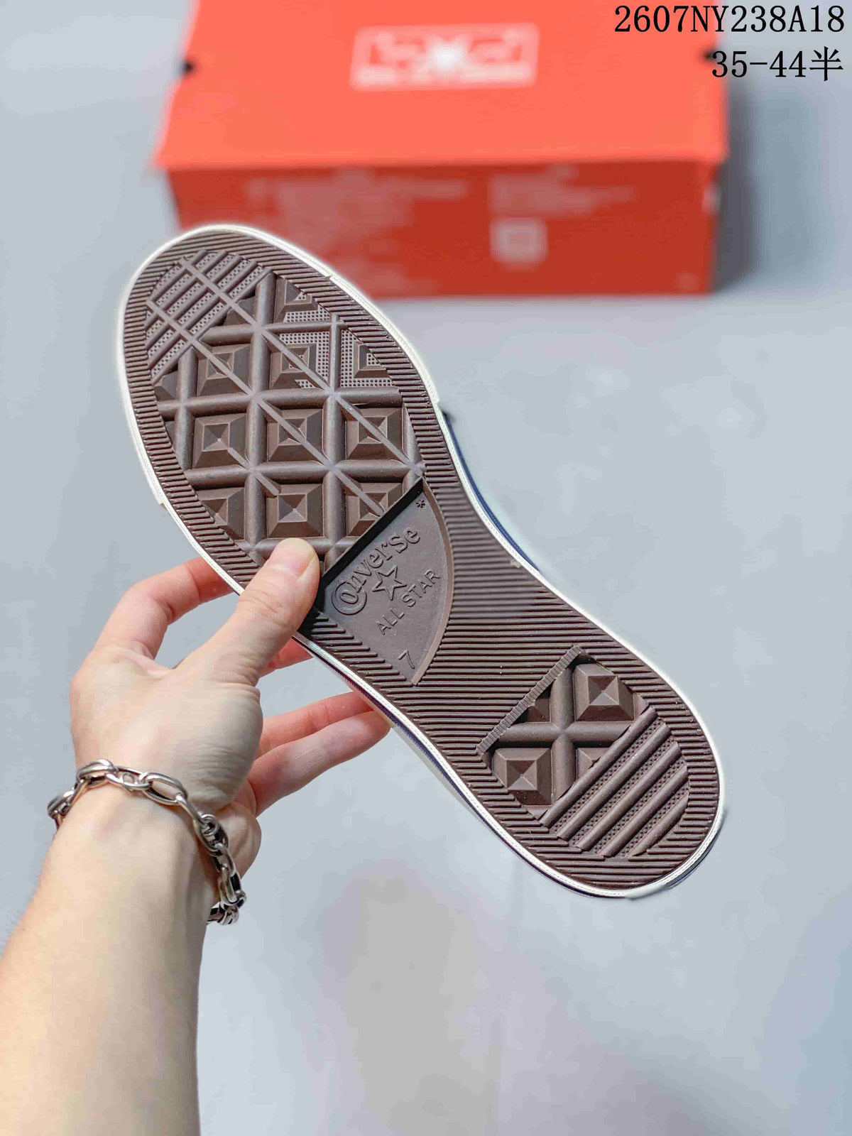 Outsole view of an off-white Converse sneaker showing the textured geometric tread and Converse All Star branding.