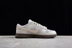 Side profile highlighting the low-top shape, gray panels, beige Swoosh and dark brown sole.