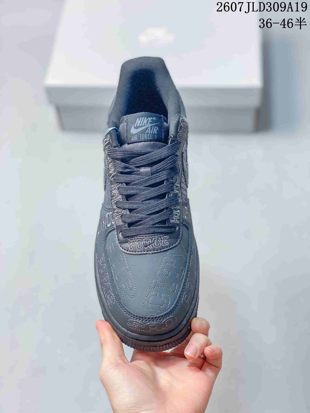 Top view of the dark gray sneaker showing the padded tongue, woven laces and graphic lettering around the toe box.