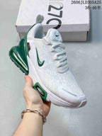 Angled side view of the white and green sneaker with visible heel air unit
