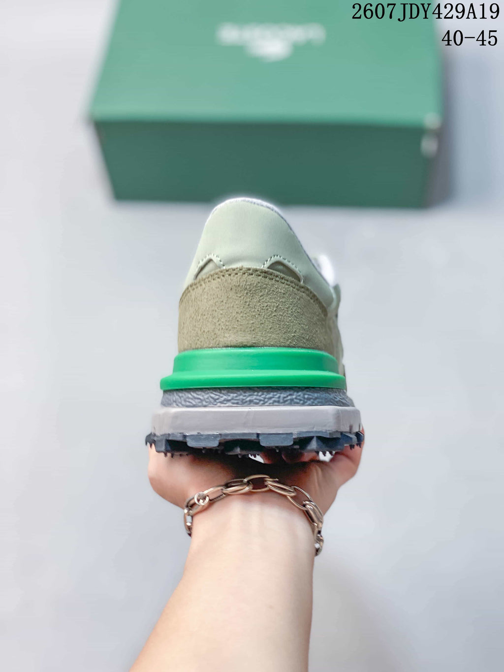 Rear view of the sneaker showing the khaki heel panel, bright green heel accent, and layered sole.