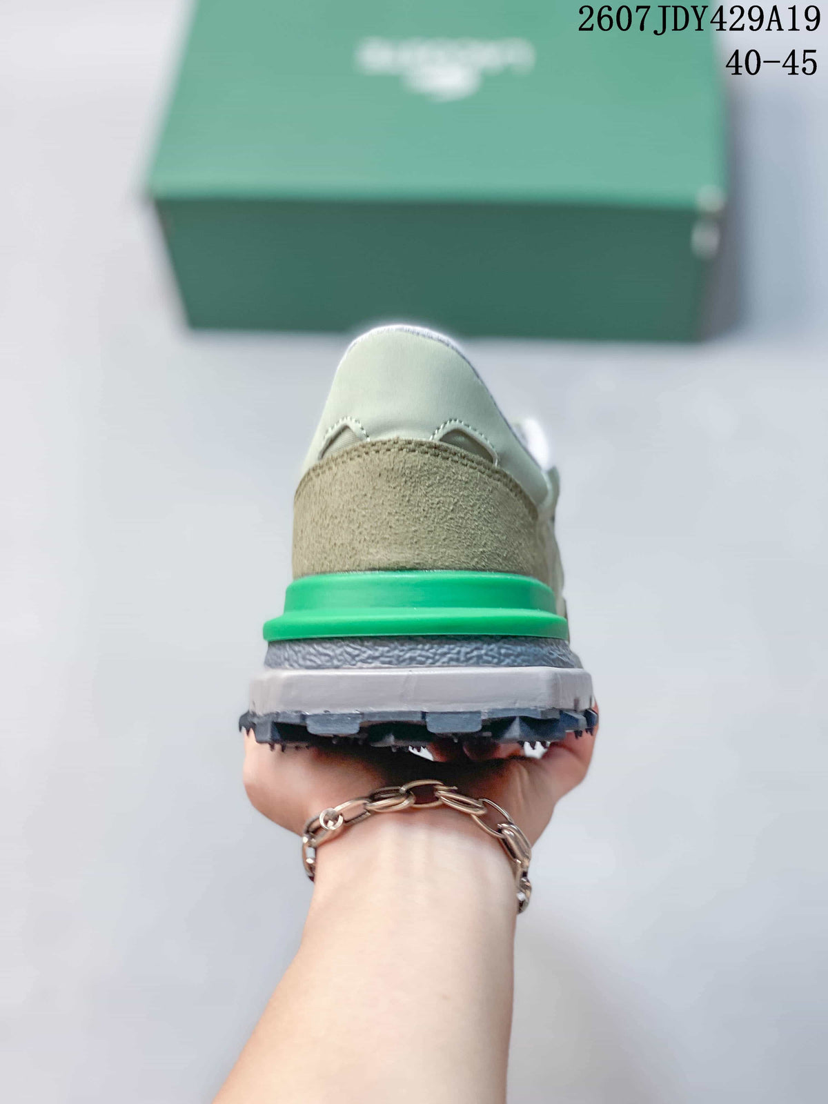 Rear view of the sneaker showing the khaki heel panel, bright green heel accent, and layered sole.