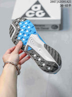 Underside view of the sneaker showing the blue, white, and dark gray lugged outsole pattern.