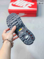 Underside view of a black sneaker showing the sculpted outsole with geometric tread and circular details.