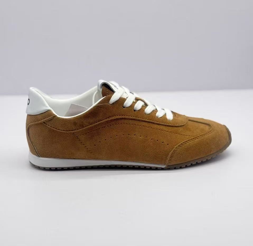 Lateral side view showing the brown textured upper, perforated detailing, white heel accent, and dark outsole.