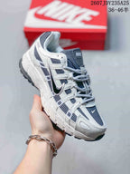 Angled side view of the white and dark navy Nike P-6000 sneaker with layered side panels and textured outsole.