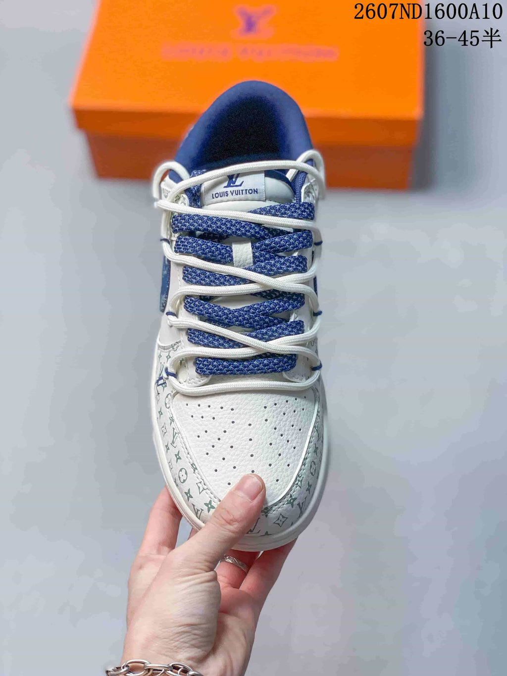 Top view showing the perforated white toe box, blue woven laces and repeating patterned trim.
