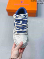 Top view showing the perforated white toe box, blue woven laces and repeating patterned trim.