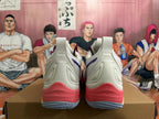 Rear view of white Mizuno Wave Momentum 3 shoes with coral-colored heel accents.