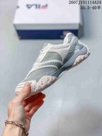 Side profile of the gray and white low-top sneaker showing layered panels and the raised outsole.