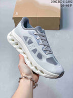 Close-up side view of a light grey Cloudtilt Remix sneaker with a white sculpted sole