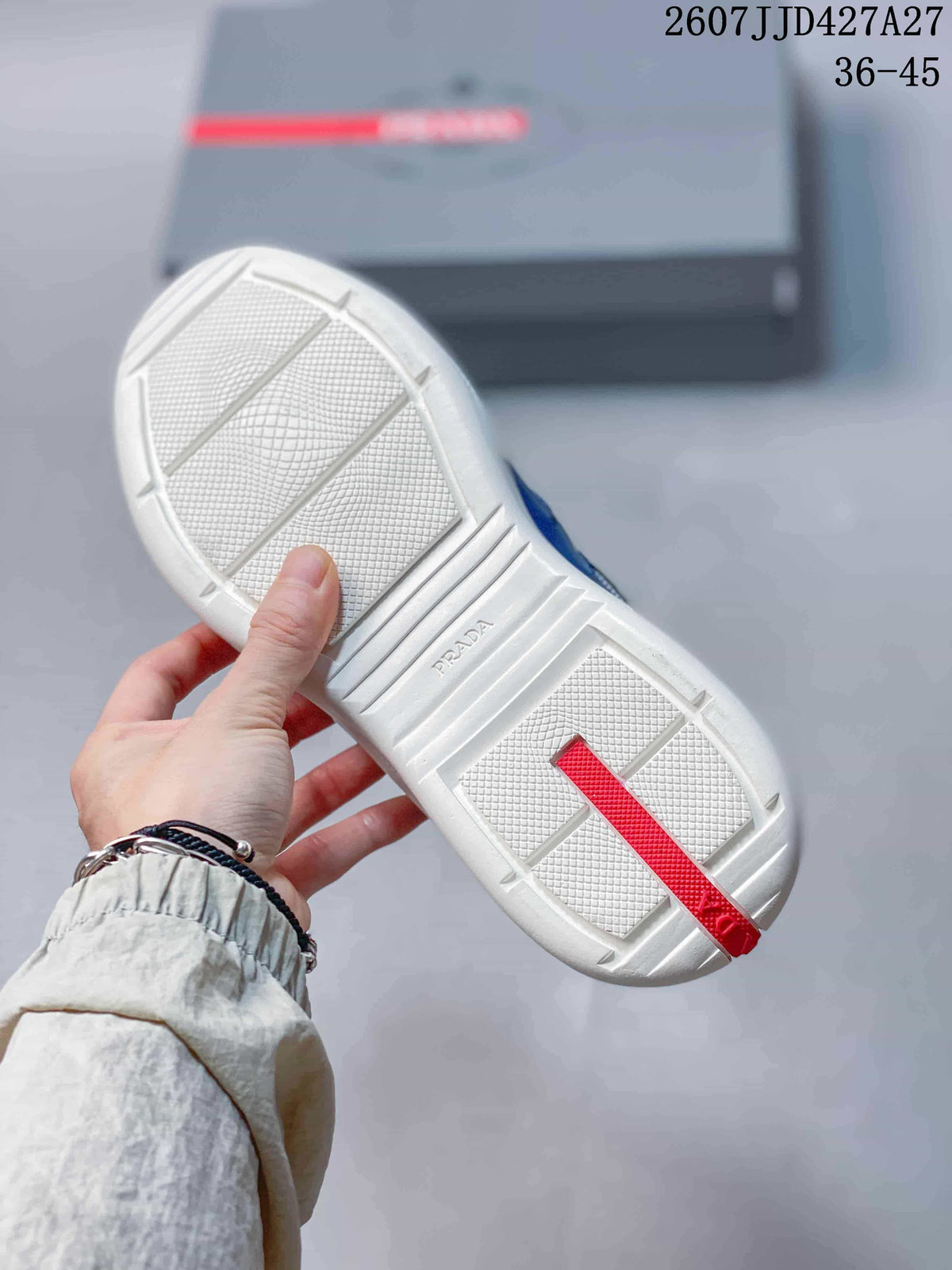 Underside view of the sneaker showing the white textured outsole and red heel detail.