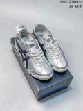 Pair of silver and black Onitsuka Tiger low-top sneakers displayed on a shoebox.