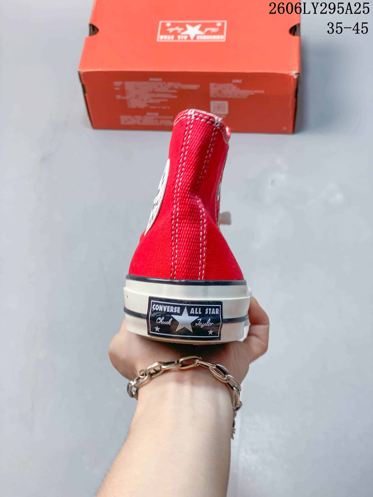 Rear view of a red high-top Converse sneaker showing the heel label, white midsole, and black sidewall stripe.