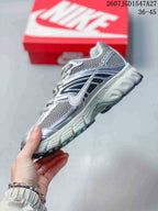 Side profile of the sneaker showing mesh panels, layered overlays, side swoosh detailing and a textured sole.
