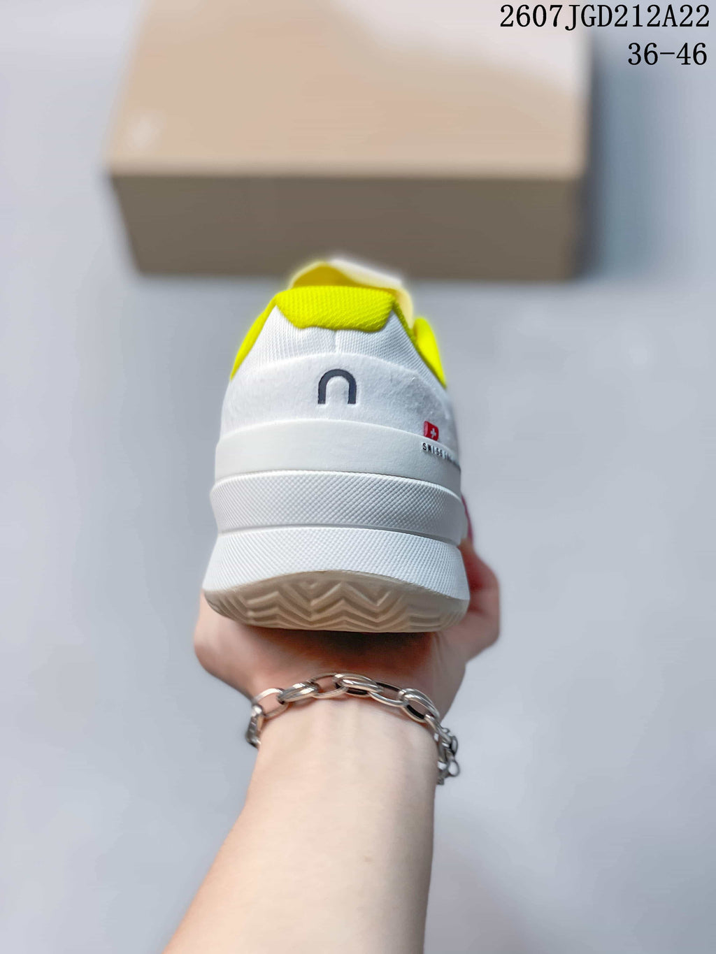 Rear view of the white sneaker showing the layered heel, neon yellow collar lining and On branding.