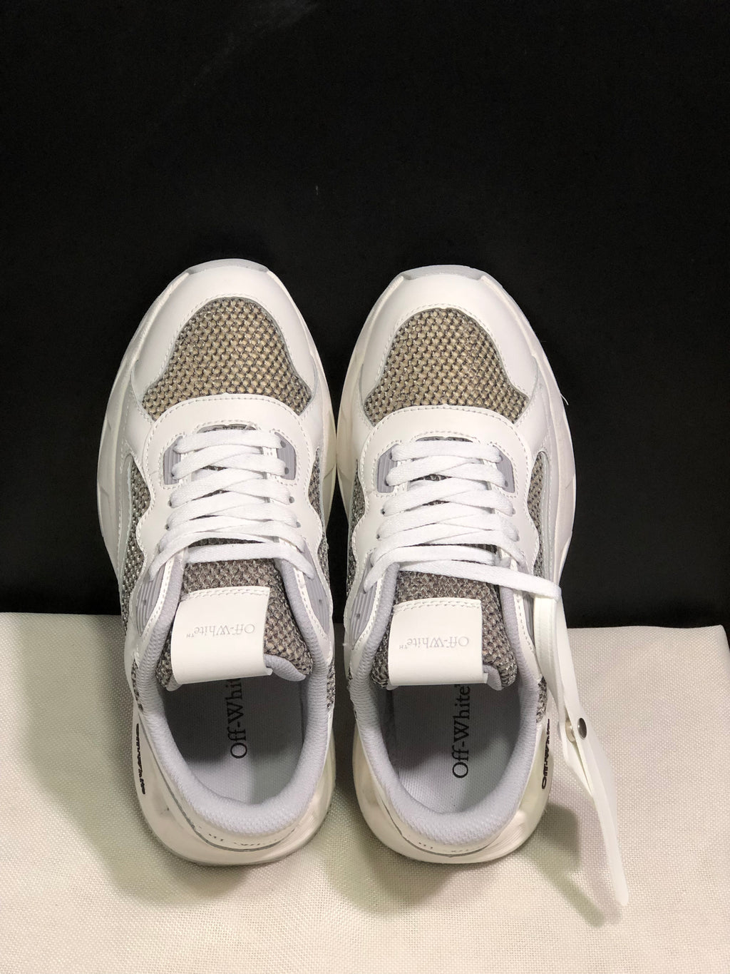 Top view showing white laces, grey textured panels and padded collars.