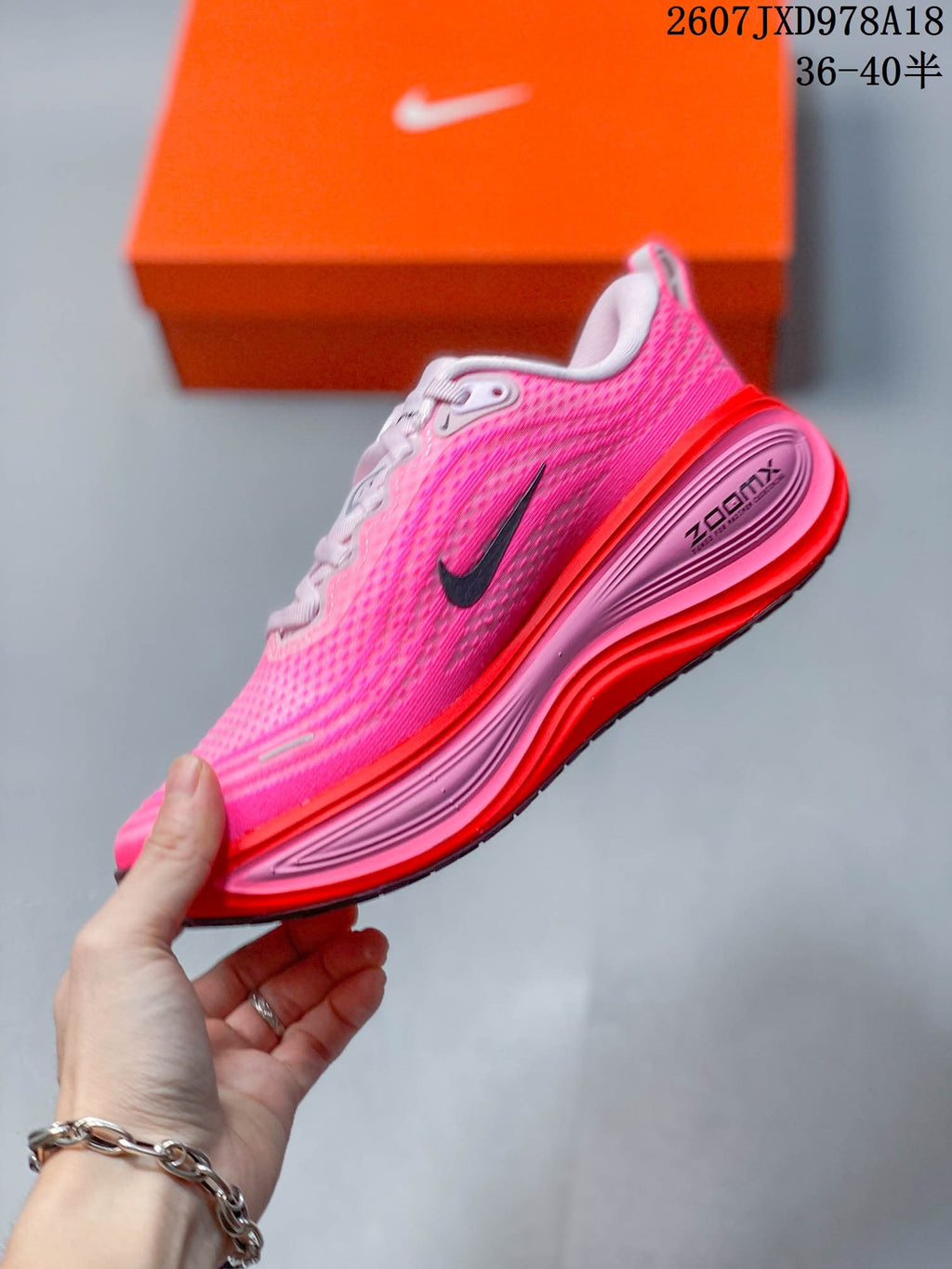 Side profile of the pink and red sneaker showing the Nike Swoosh, sculpted midsole and visible ZoomX branding.
