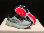 Angled view showing one sneaker's outsole with black and red traction sections and the sculpted midsole.