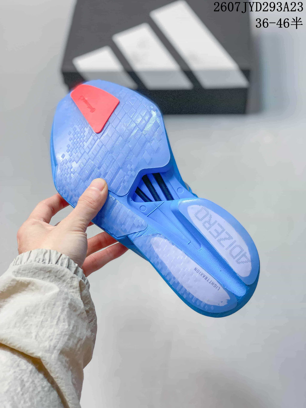 Underside view of the blue sneaker showing the textured outsole, red heel detail and Lightstrike Zero insole branding.
