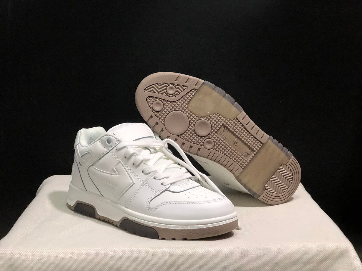Angled product view with one sneaker lifted to show the textured rubber outsole and tread pattern.