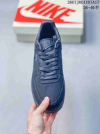 Top view of the black sneaker showing tonal laces, padded tongue, textured toe box and embroidered forefoot detail.
