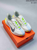 Pair of light-colored Nike running sneakers displayed on an orange shoebox; white uppers feature pale blue, black, and lime accents. Image text shows JDD298A18 and a 36–46 size range.