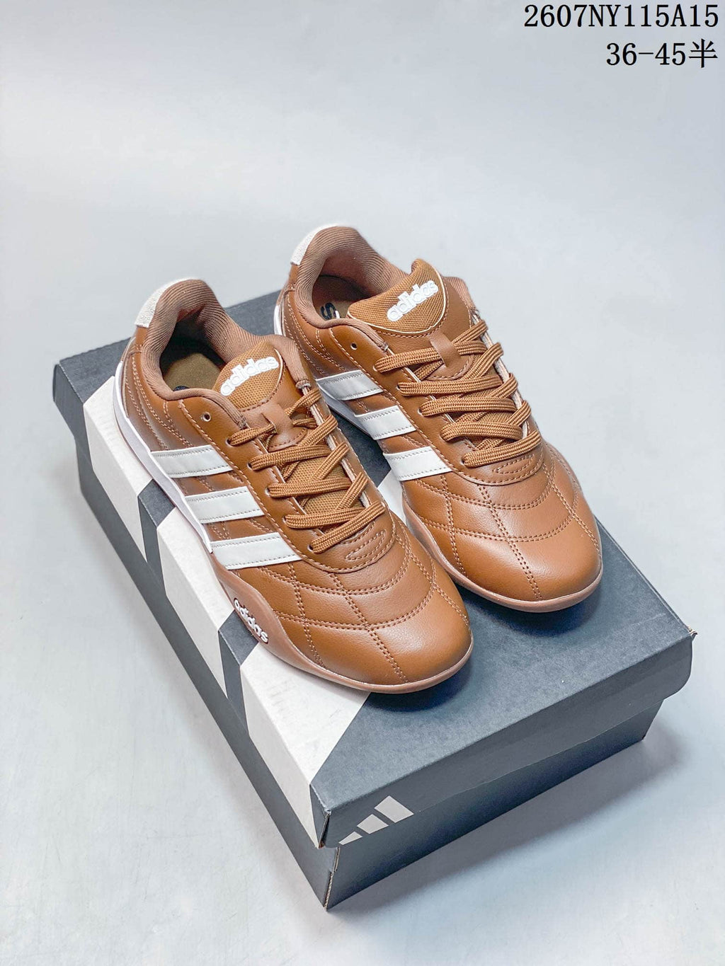 Pair of brown and white adidas low-top sneakers displayed on a shoebox.