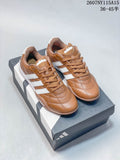 Pair of brown and white adidas low-top sneakers displayed on a shoebox.