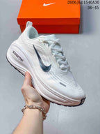 White Nike Vomero Plus running shoe with a dark Swoosh and matching pale sole.