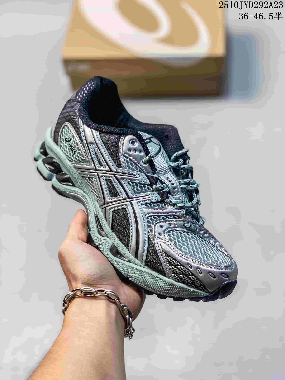 Close-up of a dark gray and mint sneaker with layered side stripes and mesh-like upper.