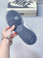 Underside view showing the dark textured rubber outsole and circular traction pattern of a Nike SB Dunk Low sneaker.