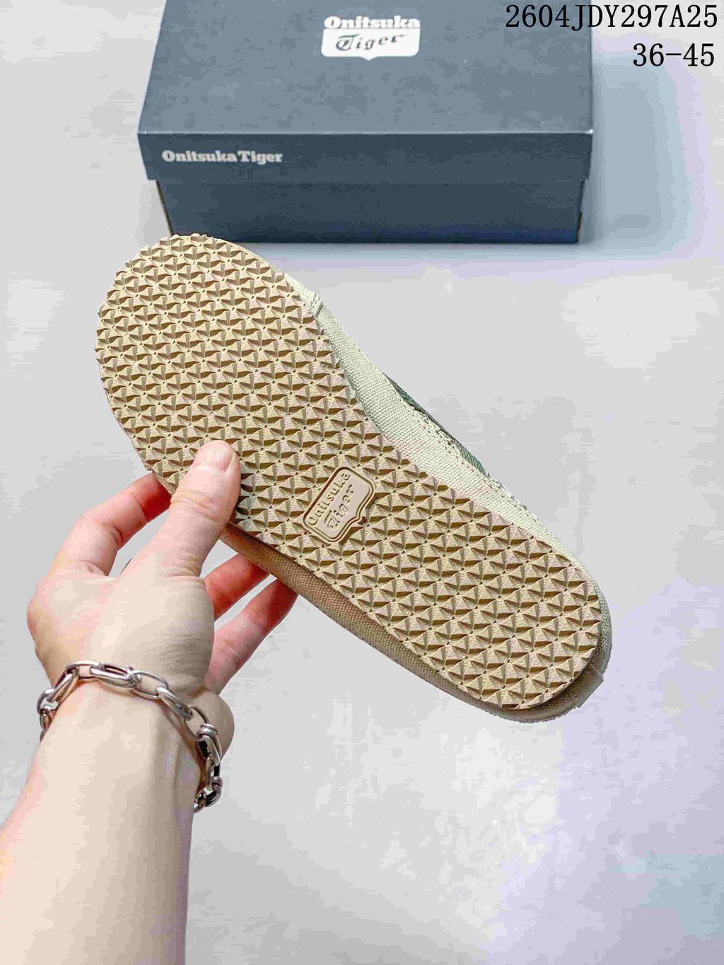 Underside of the sneaker showing its repeating textured rubber outsole pattern and branded outsole detail.