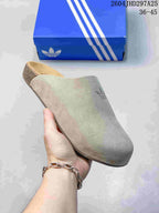 Angled view of the beige adidas mule slide showing the closed toe, tonal Trefoil detail and contoured sole.
