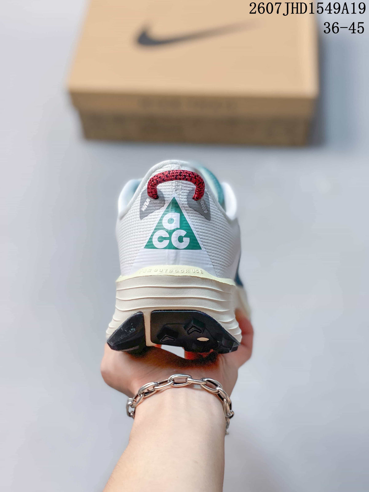 Rear view showing the padded heel, red pull tab, and teal graphic detail on the sneaker.