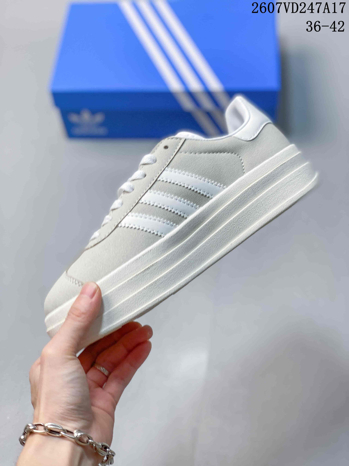 Side profile of the light gray low-top sneaker with white stripes and a raised layered sole.