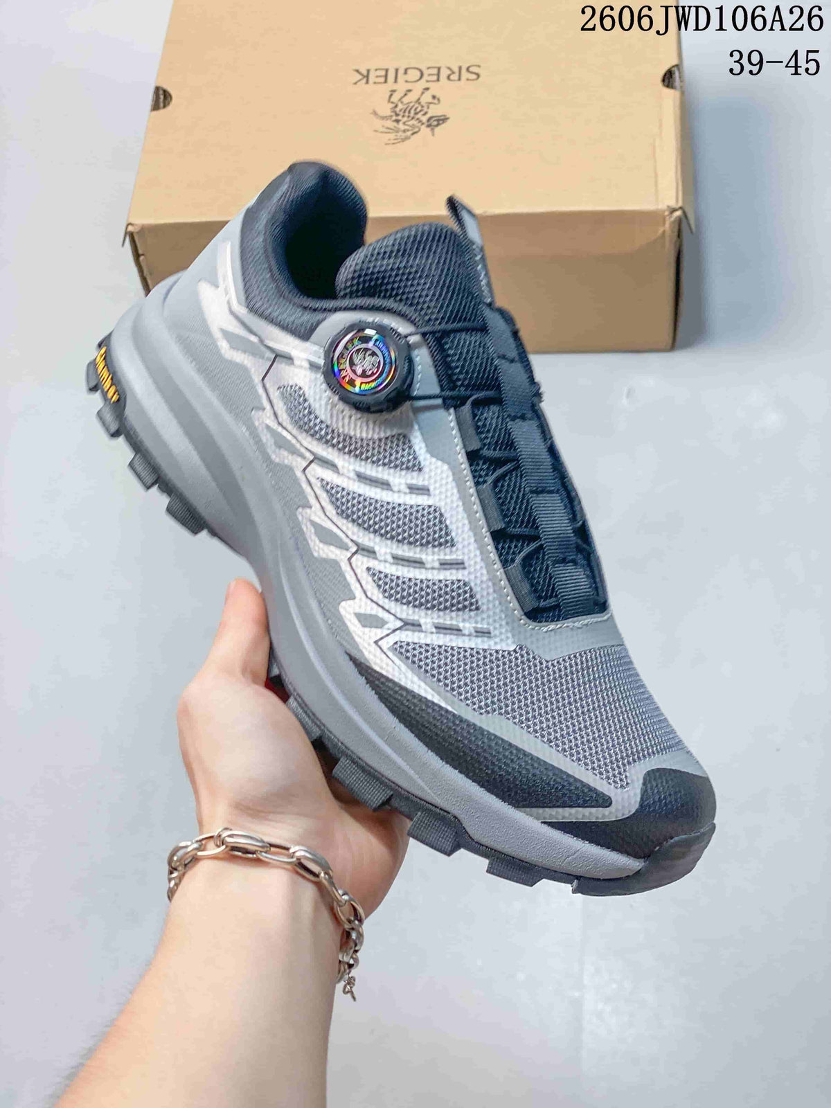 Side view of a light gray SREGIEK sneaker with dark accents, mesh-look panels, dial-style closure, and treaded sole.